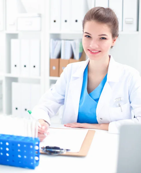 Woman researcher is surrounded by medical vials and flasks — Stock Photo, Image