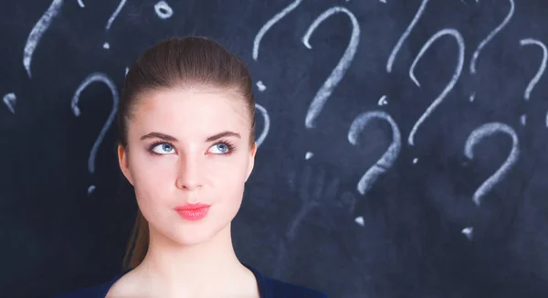 Young girl with question mark on a gray background — Stock Photo, Image