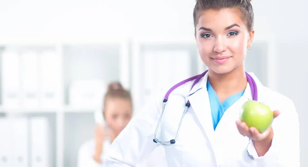 Female doctor hand holding a green apple, standing — Stock Photo, Image