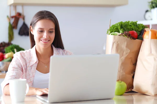 Lächelnde Frau beim Online-Shopping mit Tablet und Kreditkarte in der Küche. Lächelnde Frau — Stockfoto