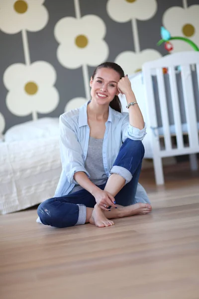 Jonge vrouw doet yoga thuis in de lotuspositie. Jonge vrouw doet yoga. — Stockfoto