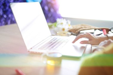 Kredi kartı tutan ve dizüstü bilgisayar kullanan genç bir kadın. Çevrimiçi alışveriş kavramı