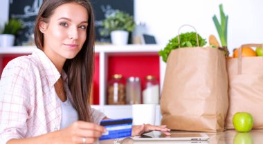 Mutfakta ipad 'ini kullanan genç bir kadın. Genç kadın.