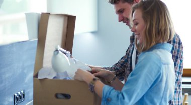 Genç bir çift yeni evde büyük karton kutu taşıyan. Ev taşıma. Genç Çift