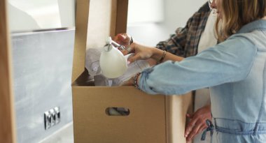 Genç bir çift yeni evde büyük karton kutu taşıyan. Ev taşıma. Genç Çift