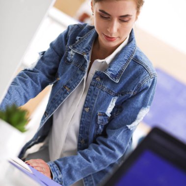 Masanın yanında duran iki genç kadın enstrüman, plan ve dizüstü bilgisayarla.