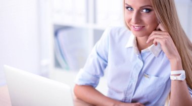 Ofiste dizüstü bilgisayarı olan çekici bir iş kadını.