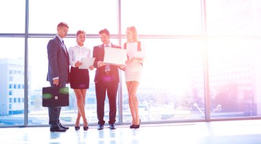 Grup iş adamları toplantı sırasında dizüstü bilgisayar ile sunum yapıyor. Grup iş adamları