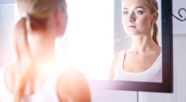 güzel genç kız temiz bir cilt bir el ile bir yanak dokunur.