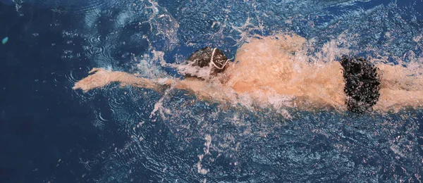 Чоловік плаває у басейні. Підводне фото. Чоловічий плавець . — стокове фото