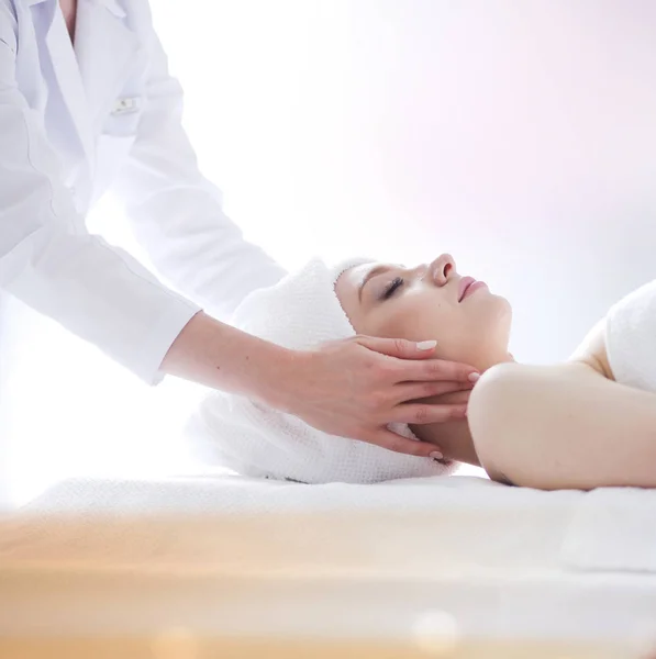 Mujer joven acostada en una mesa de masaje, relajándose con los ojos cerrados. Una mujer. Salón de spa — Foto de Stock