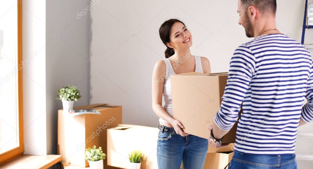 Happy young couple unpacking or packing boxes and moving into a new home. young couple