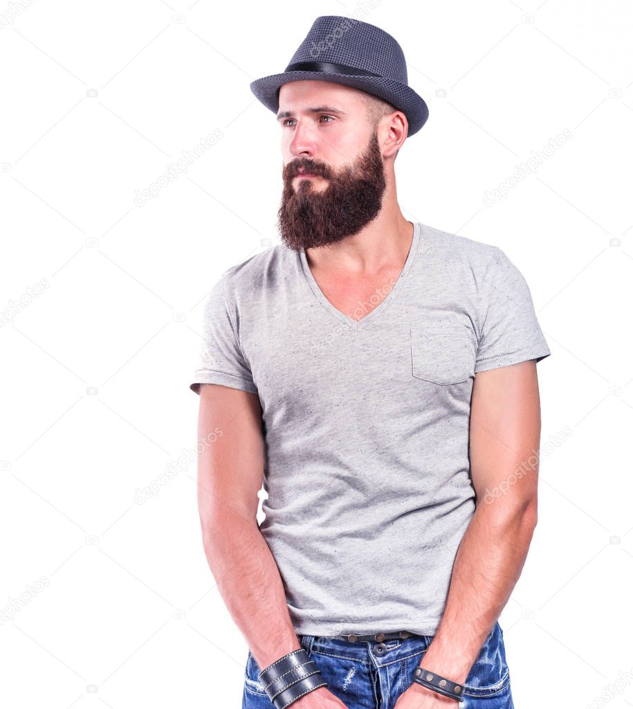 Portrait of handsome bearded man in hat standing , isolated on grey background