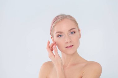 güzel genç kız temiz bir cilt bir el ile bir yanak dokunur.