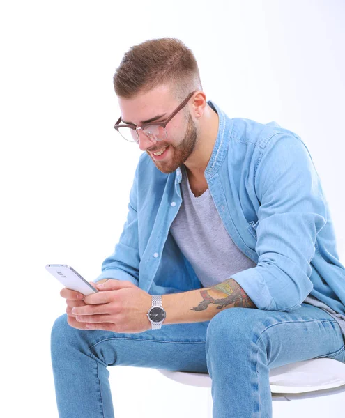 Ung man sitter på stol och med hjälp av mobiltelefon. Startupper. Ung entreprenör. — Stockfoto