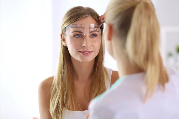 Permanent makeup for eyebrows. Closeup of beautiful woman with thick brows in beauty salon. — Stock Photo, Image