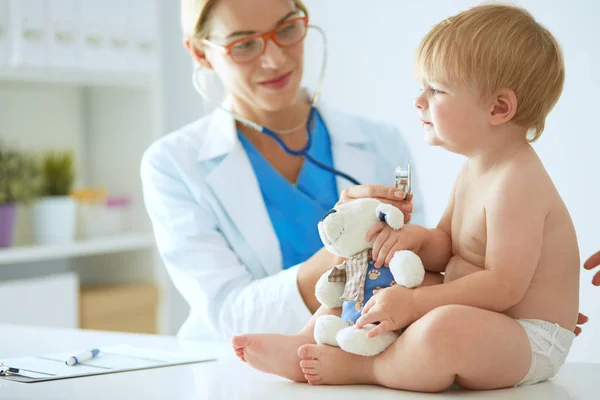 Vrouwelijke arts luistert kind met een stethoscoop in de kliniek — Stockfoto