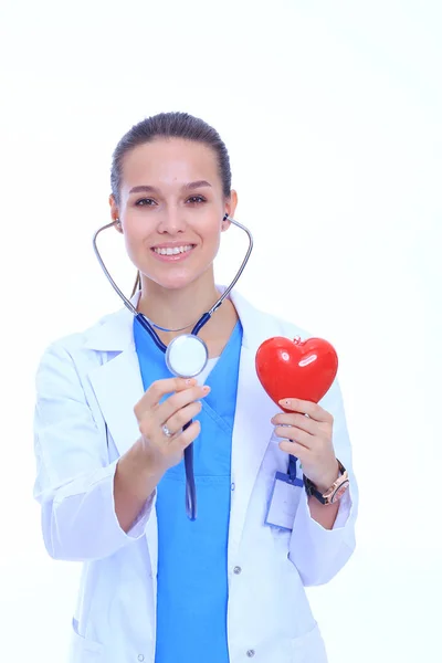 Médica feminina positiva em pé com estetoscópio e símbolo de coração vermelho isolado. Mulher médica — Fotografia de Stock