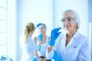 Güzel kadın elinde şırıngayla doktorun yanında duruyor..