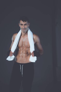 Siyah arka plan üzerine ayakta güçlü atletik adam.