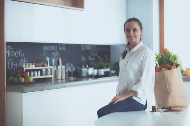 Giderleri planlama ve mutfağını faturalarında ödeme genç kadın.