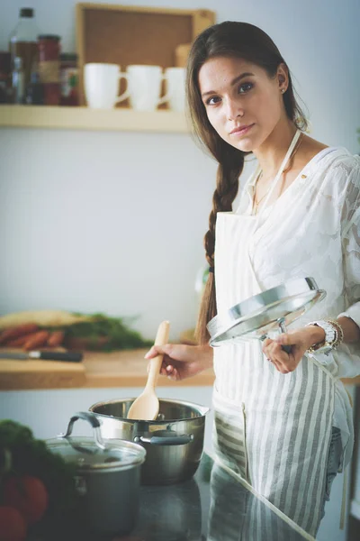 Cooking woman in kitchen with wooden spoon. Cooking woman