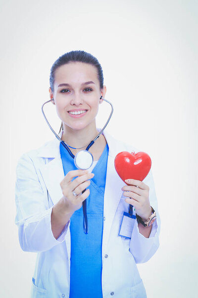 Positive female doctor standing with stethoscope and red heart symbol isolated. Woman doctor