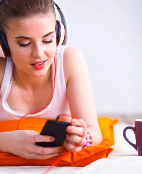 Mujer joven tumbada en el suelo y escuchando música — Foto de Stock