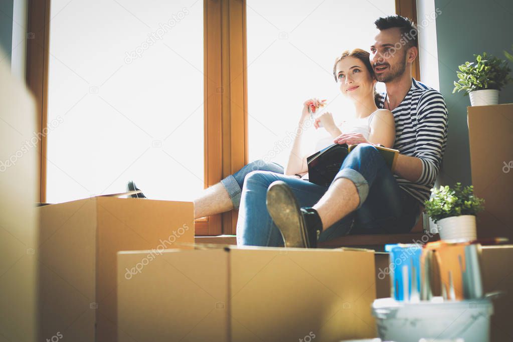 Couple moving in house sitting on the windowsill. Couple