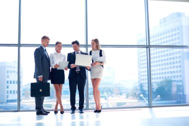 Grup iş adamları toplantı sırasında dizüstü bilgisayar ile sunum yapıyor. Grup iş adamları