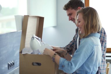 Genç bir çift yeni evde büyük karton kutu taşıyan. Ev taşıma. Genç Çift