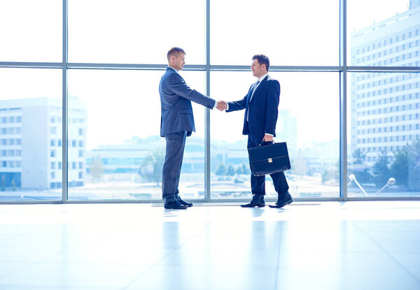 Изображение двух успешных бизнесменов, пожимающих друг другу руки
