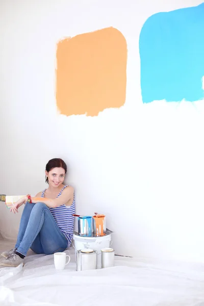 여자 선택 페인트 컬러 나무 바닥에 앉아 새 집에 대 한 견본에서. 집에 있는 여자 — 스톡 사진