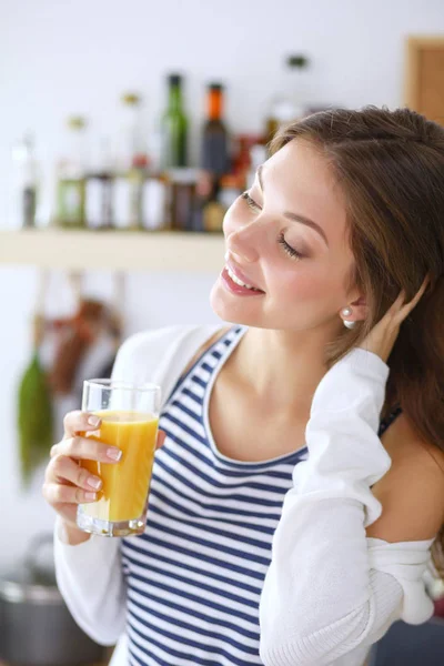 Jovem mulher de pé perto da mesa na cozinha. Jovem mulher . — Fotografia de Stock