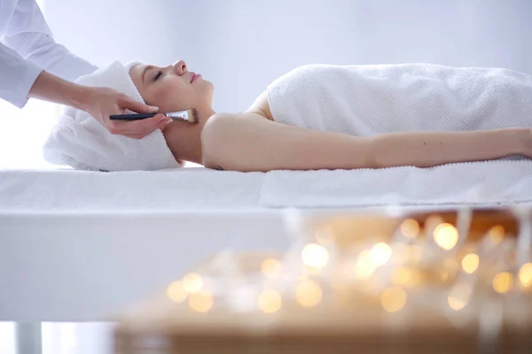 Junge Frau auf Massagetisch liegend, entspannt mit geschlossenen Augen. Frau. Wellness Salon — Stockfoto
