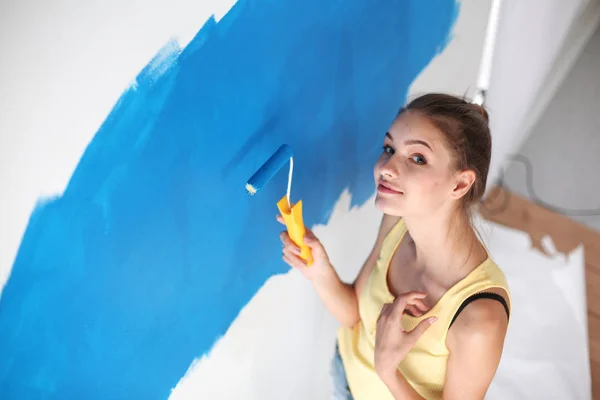 Glad vacker ung kvinna gör väggmålning, stående nära stege — Stockfoto