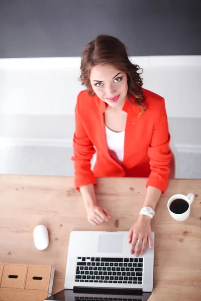 Mujer atractiva sentada en el escritorio en la oficina, trabajando con el ordenador portátil —  Fotos de Stock