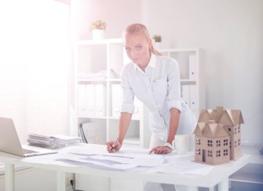 Ofisinde planları olan kadın mimarın portresi.