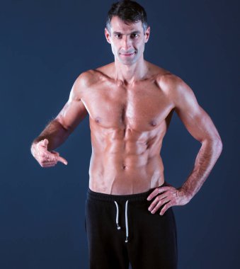 kaslı adam. Kaslı adam kas gösterilen gri arka plan üzerinde. Fitness Eğitmeni. Fitness profesyonel. Egzersiz. Mens fitness.