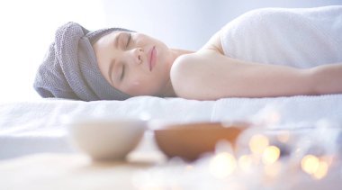 Masaj masasında uzanmış gözleri kapalı rahatlayan genç bir kadın. - Kadın. Spa salonu