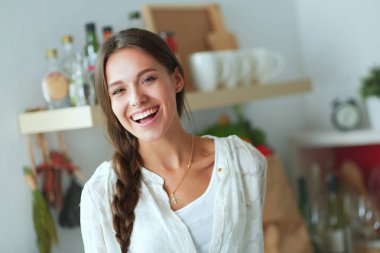 Mutfakta masanın yanında duran genç bir kadın. Genç kadın. .