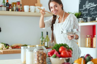 Mutfakta ahşap kaşıkla yemek pişiren kadın. Aşçı kadın.