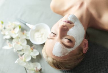 Yüz maskesi. Güzel genç kız Spa, makyajcısı kadın yüz maskesi uygulama.