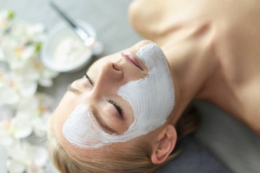 Yüz maskesi. Güzel genç kız Spa, makyajcısı kadın yüz maskesi uygulama.