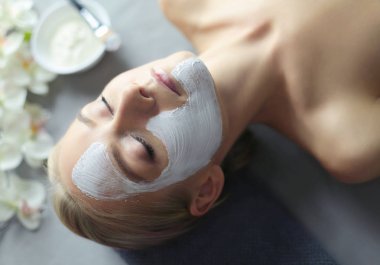 Yüz maskesi. Güzel genç kız Spa, makyajcısı kadın yüz maskesi uygulama.