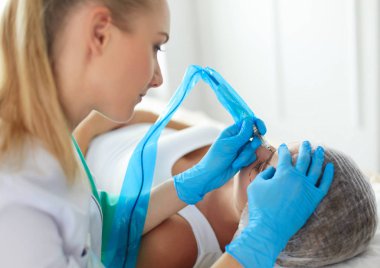 Kaşlar için kalıcı makyaj. Güzellik salonunda kalın kaşlı güzel bir kadın..