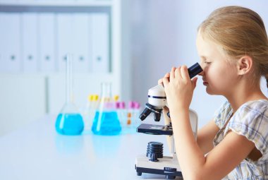 kız öğrenci fen bilgisi dersinde mikroskop aramak.