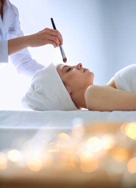 Masaj masasında uzanmış gözleri kapalı rahatlayan genç bir kadın. - Kadın. Spa salonu