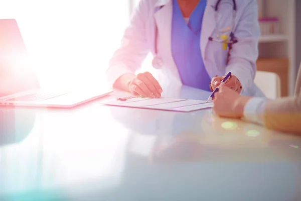 Doctor y pareja de pacientes están discutiendo algo, sentados en el escritorio. — Foto de Stock