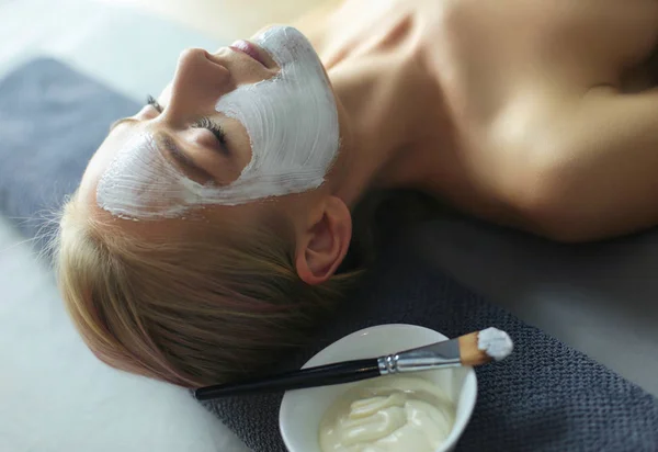 Mascarilla facial. Hermosa joven en el spa, mujer cosmética aplicando mascarilla facial . — Foto de Stock